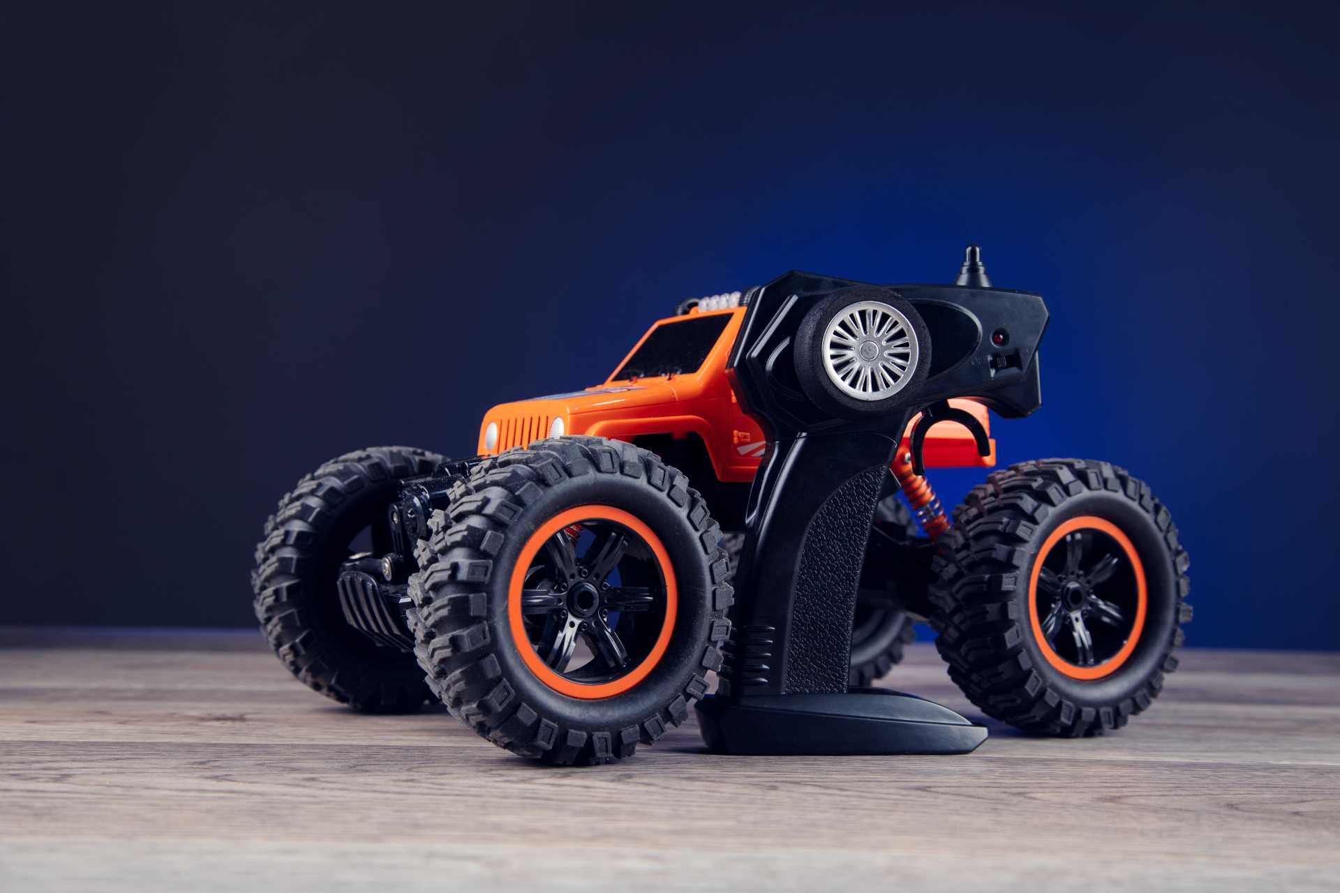 Coche RC todoterreno naranja con emisora de control remoto